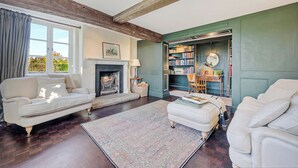 Una sala de estar con chimenea, una estantería y un sofá.