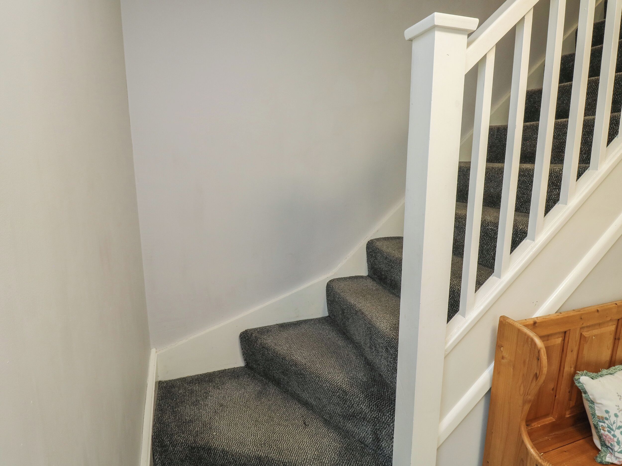 A staircase with carpeted steps and white railings.