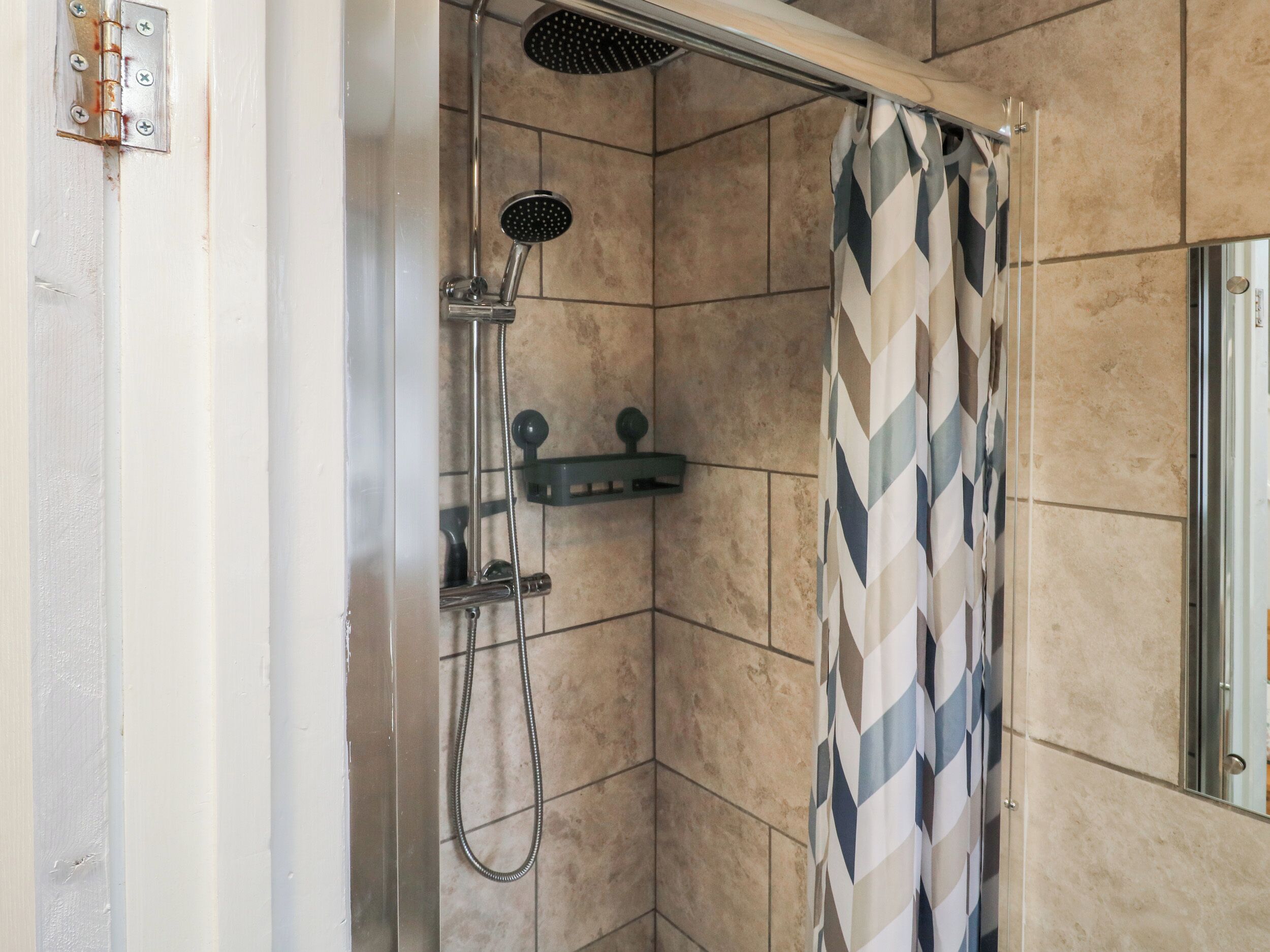 Un espace douche équipé d’un pommeau de douche, d’un pommeau de douche à main et d’un appareil de massage à main.
