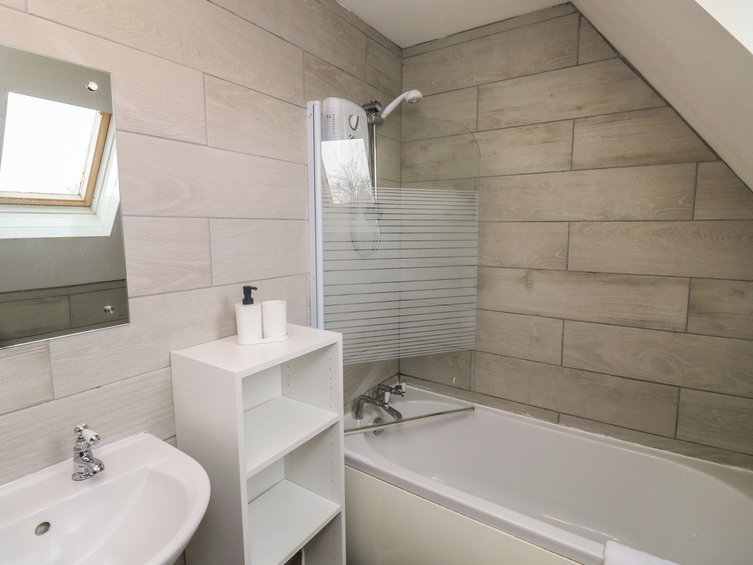 Un baño moderno con una bañera, un lavabo y un espejo.