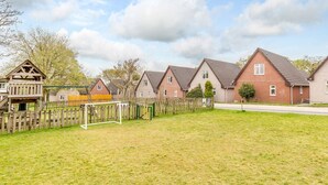 Een woonwijk met huizen, een speeltuin en een grasveld.