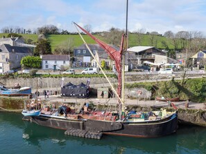A large boat docked at a pier with a town in the background. - 20 Keay Heights (St Austell)