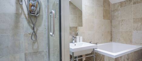 A modern bathroom with a glass shower enclosure, a white sink, and a bathtub.