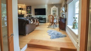Een moderne woonkamer met een bank, televisie, eettafel en stoelen.