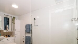 Une salle de bain moderne équipée de toilettes, d’un lavabo et d’une douche.