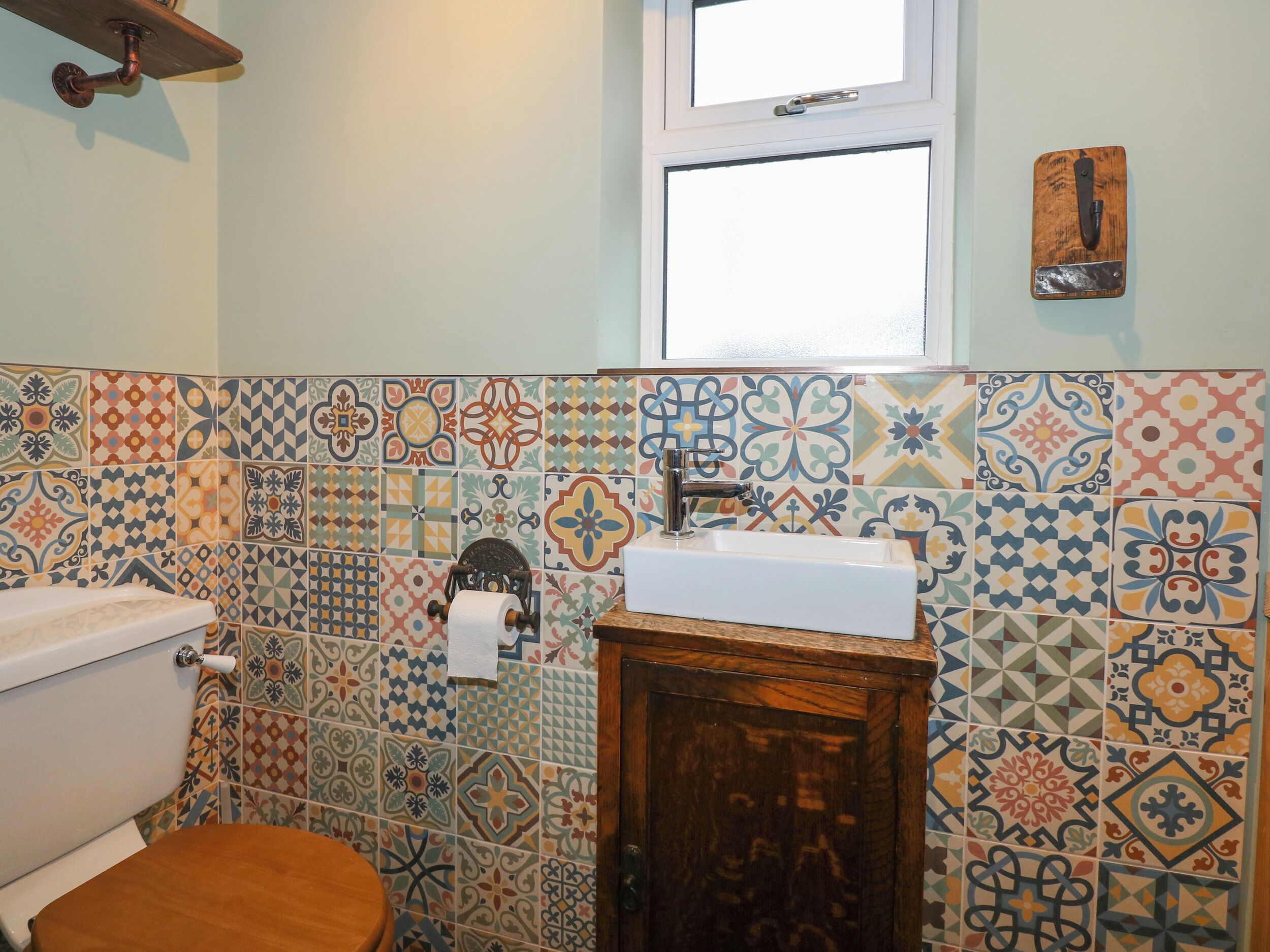 Une salle de bain avec des toilettes, un lavabo et une fenêtre.
