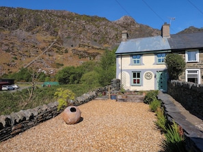 Situated in a rural setting, this traditional house offers a scenic view of the surrounding mountains.
