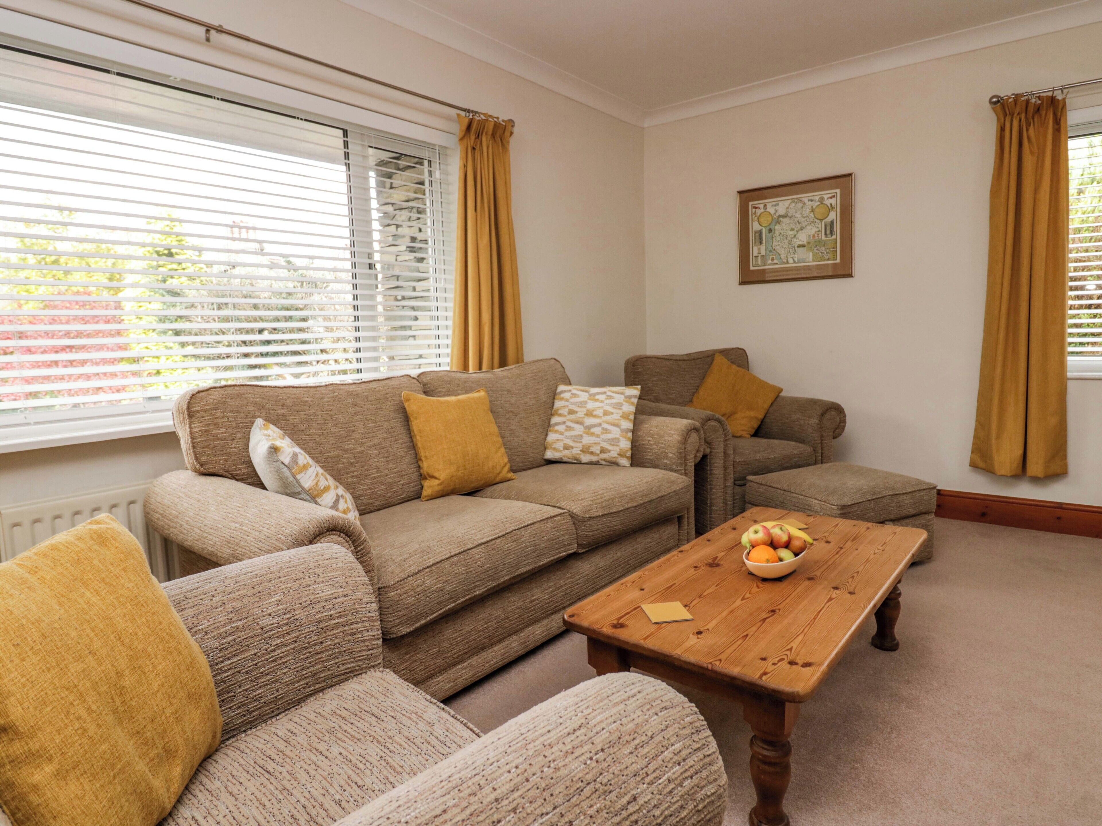 A living room with a sofa set, a wooden coffee table, and a framed map on the wall.