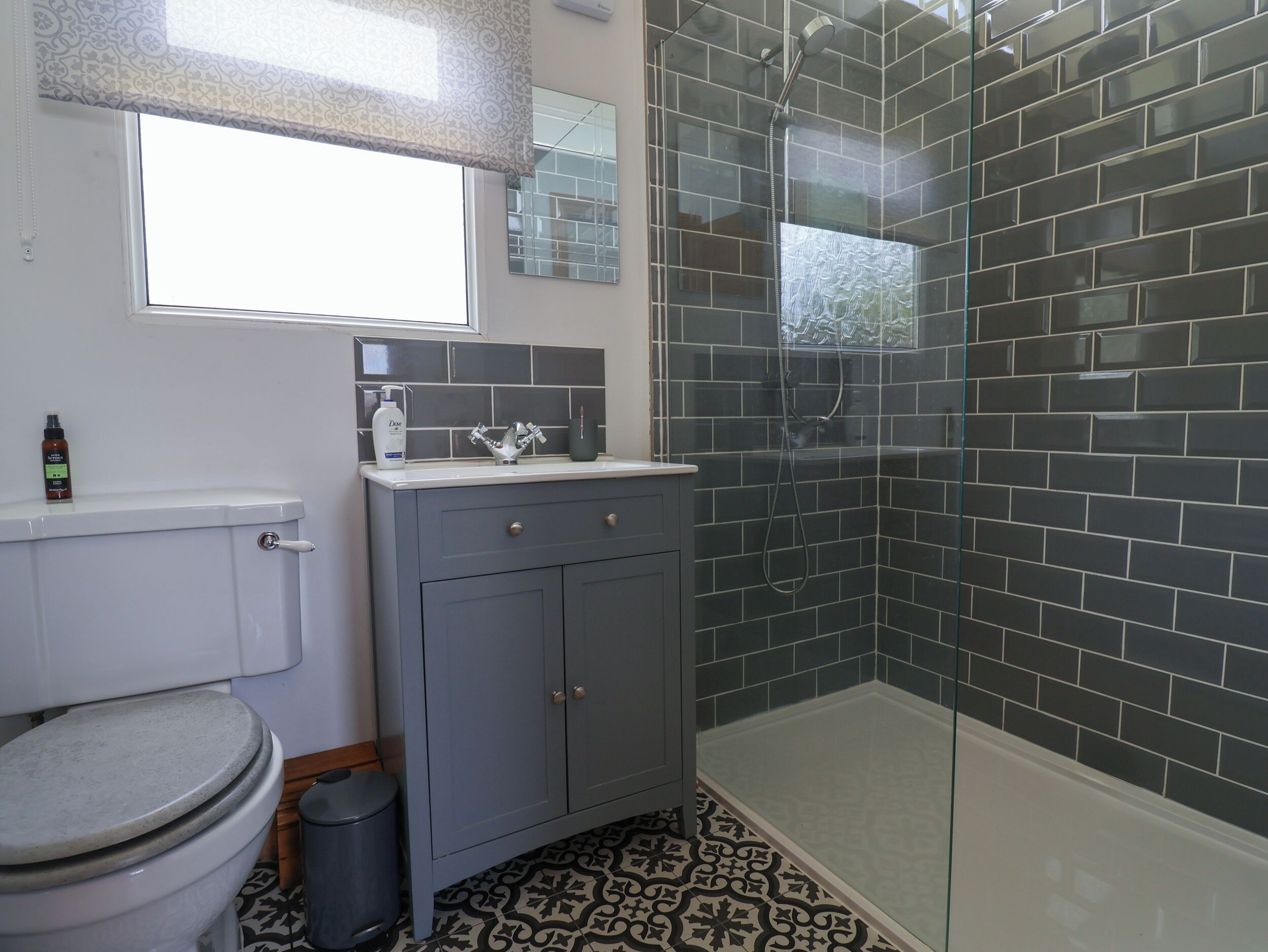 Une salle de bain avec des toilettes, un lavabo et une douche.