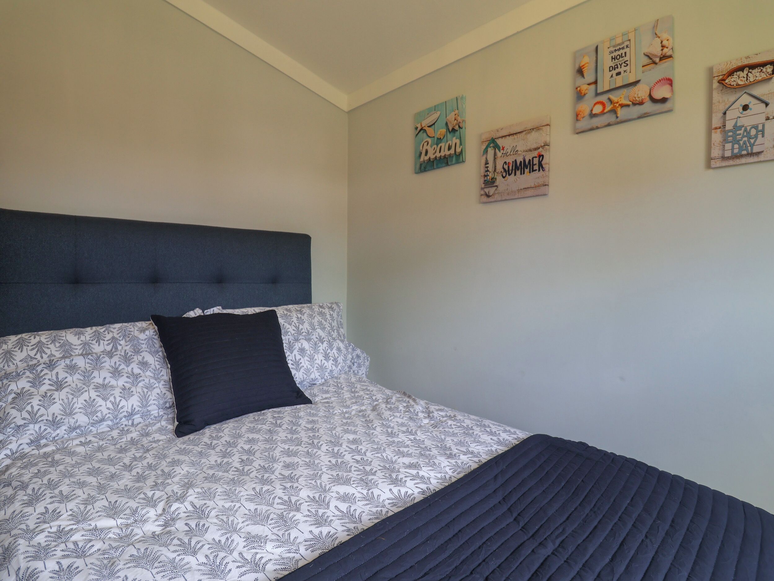Ein Schlafzimmer mit einem Bett, einem Kopfteil und Wanddekorationen.