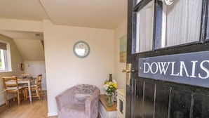 Una stanza accogliente con un'area pranzo, una poltrona comoda, un orologio a parete e una porta con la scritta "DOWLAIS".
