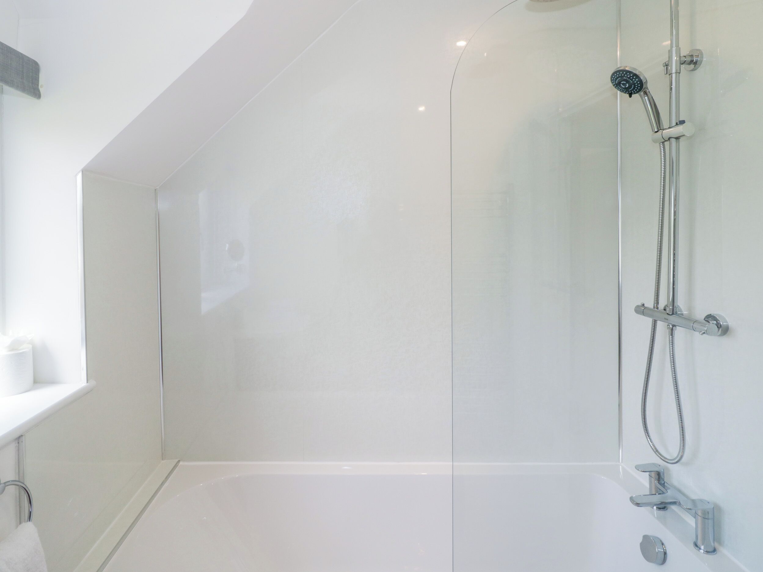 Un baño moderno con cabina de ducha de vidrio, bañera y retrete.