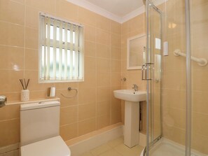 A bathroom with a toilet, sink, and glass shower enclosure. - 245 Riverside Lodge (Caernarfon)