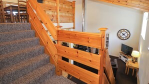 A wooden staircase with carpeted steps leading to a loft area. - Igamogam (Caernarfon)