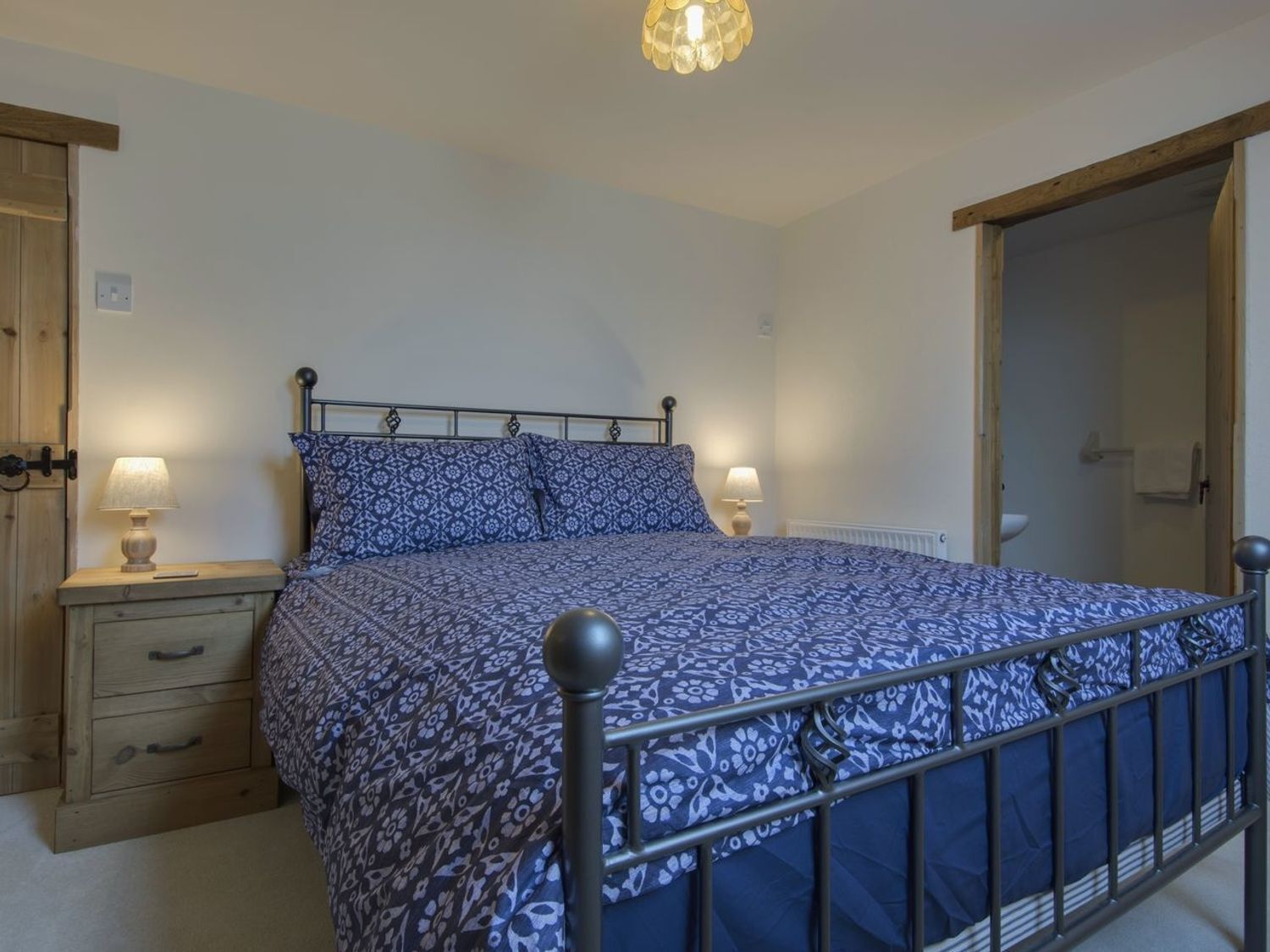 A bedroom with a bed, bedside tables, and a wardrobe.
