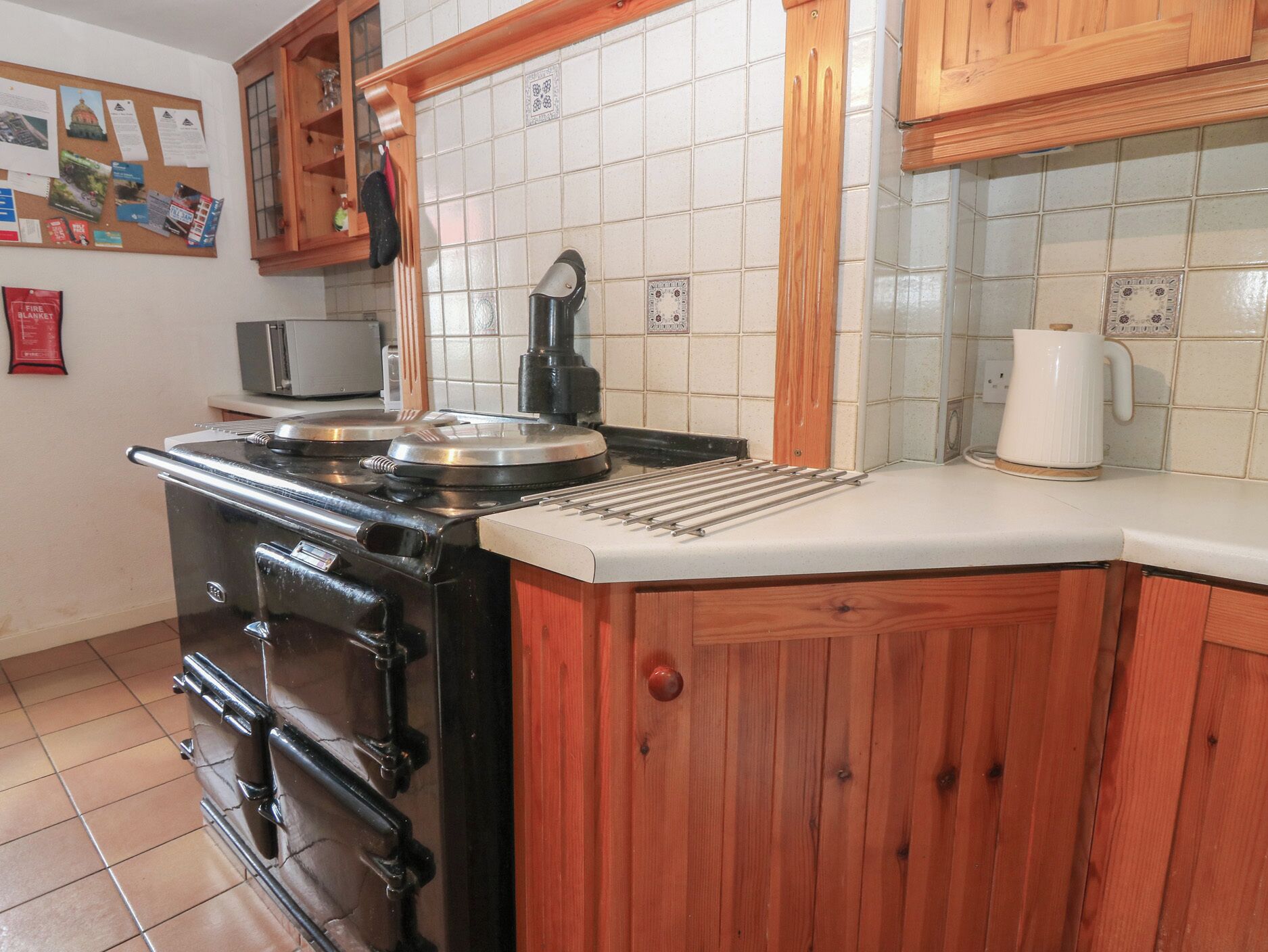 A kitchen with a stove, microwave, and wooden cabinets.