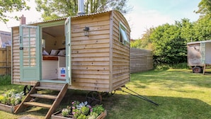 A wooden mobile home with a green door, a small porch, and a window. - Acres Meadow (Dorchester)