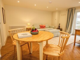 Una sala acogedora con una mesa de comedor de madera, sillas, un sofá y un radiador.