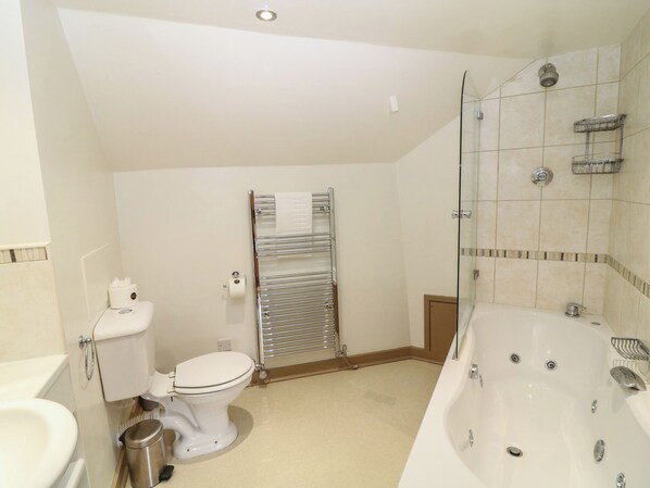 A bathroom with a toilet, bidet, and a bathtub.