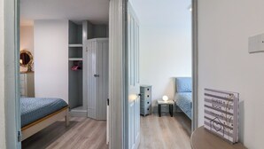 A bedroom with a bed, a bedside table with a lamp, a wardrobe, and a sign on the wall. - Cosy Nest (Glastonbury)