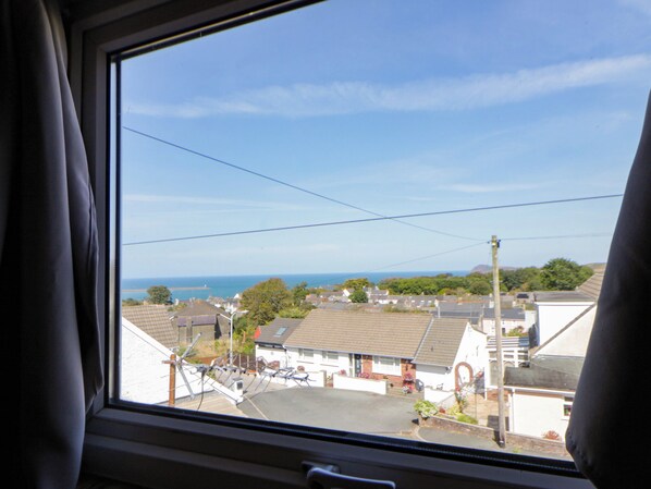 A residential area with houses, a clear sky, and a view of the sea.
