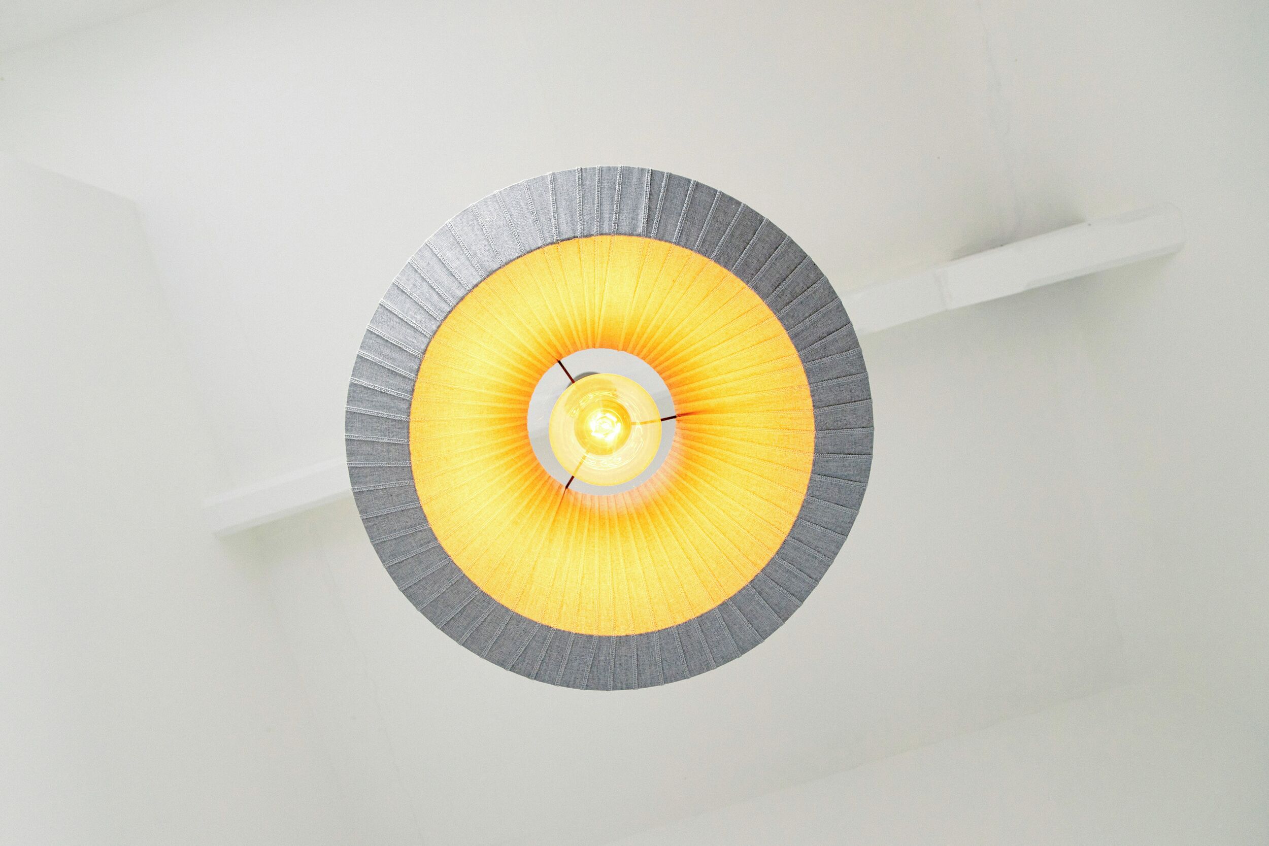 A circular ceiling light fixture with a central glowing element and a grey outer ring.