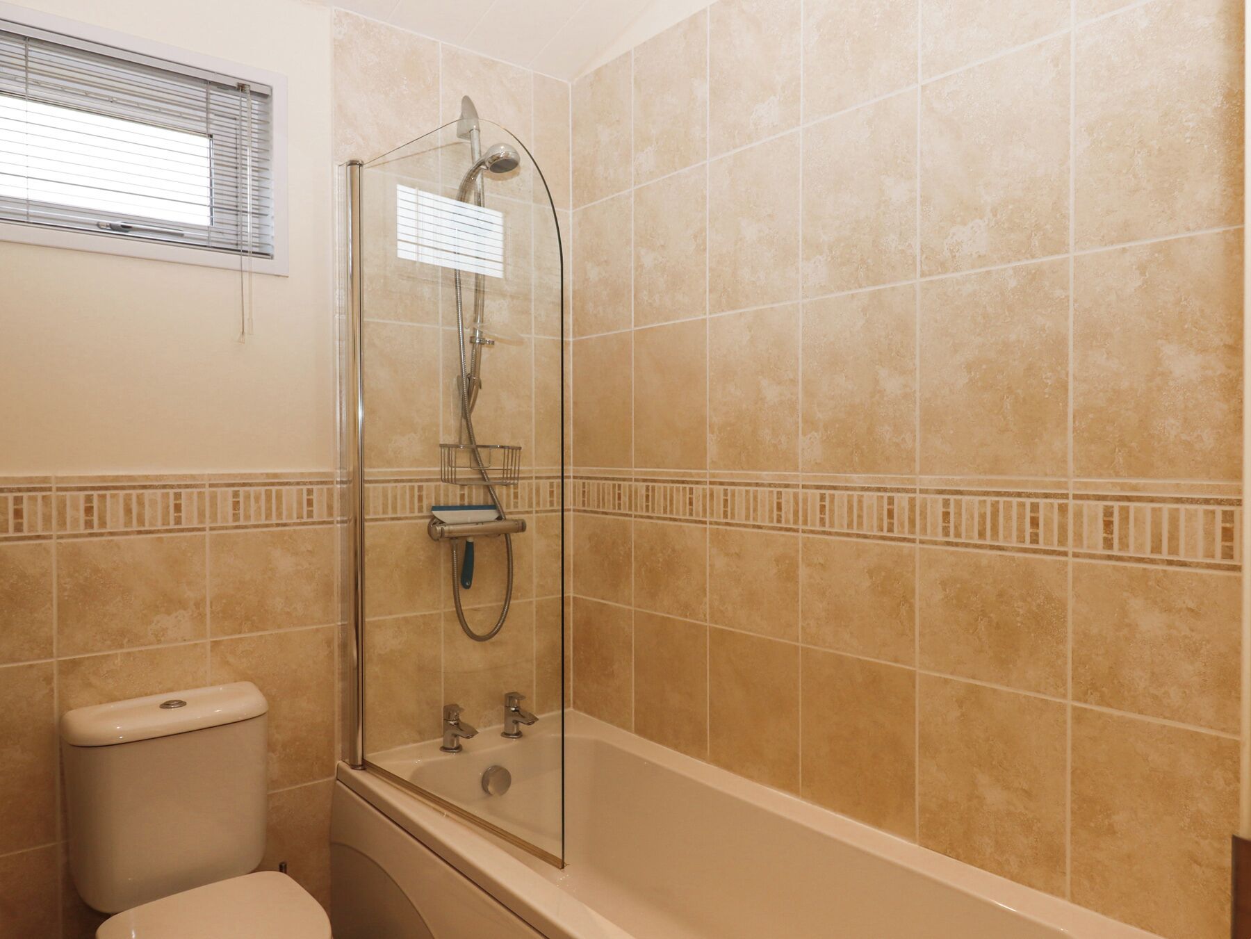 A bathroom with a glass-enclosed shower, a toilet, and a bathtub.