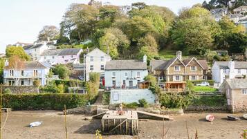 A coastal village with a prominent white building labeled "The Swan Inn" and a small dock area with boats.