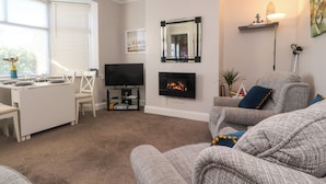 A living room with a flat-screen TV, fireplace, and grey sofas. - Lytham House (Lytham St. Anne's)