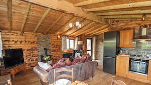 A cozy log cabin interior with a living area, dining space, and kitchen. - Stag Lodge Holiday Retreat (Whitby)