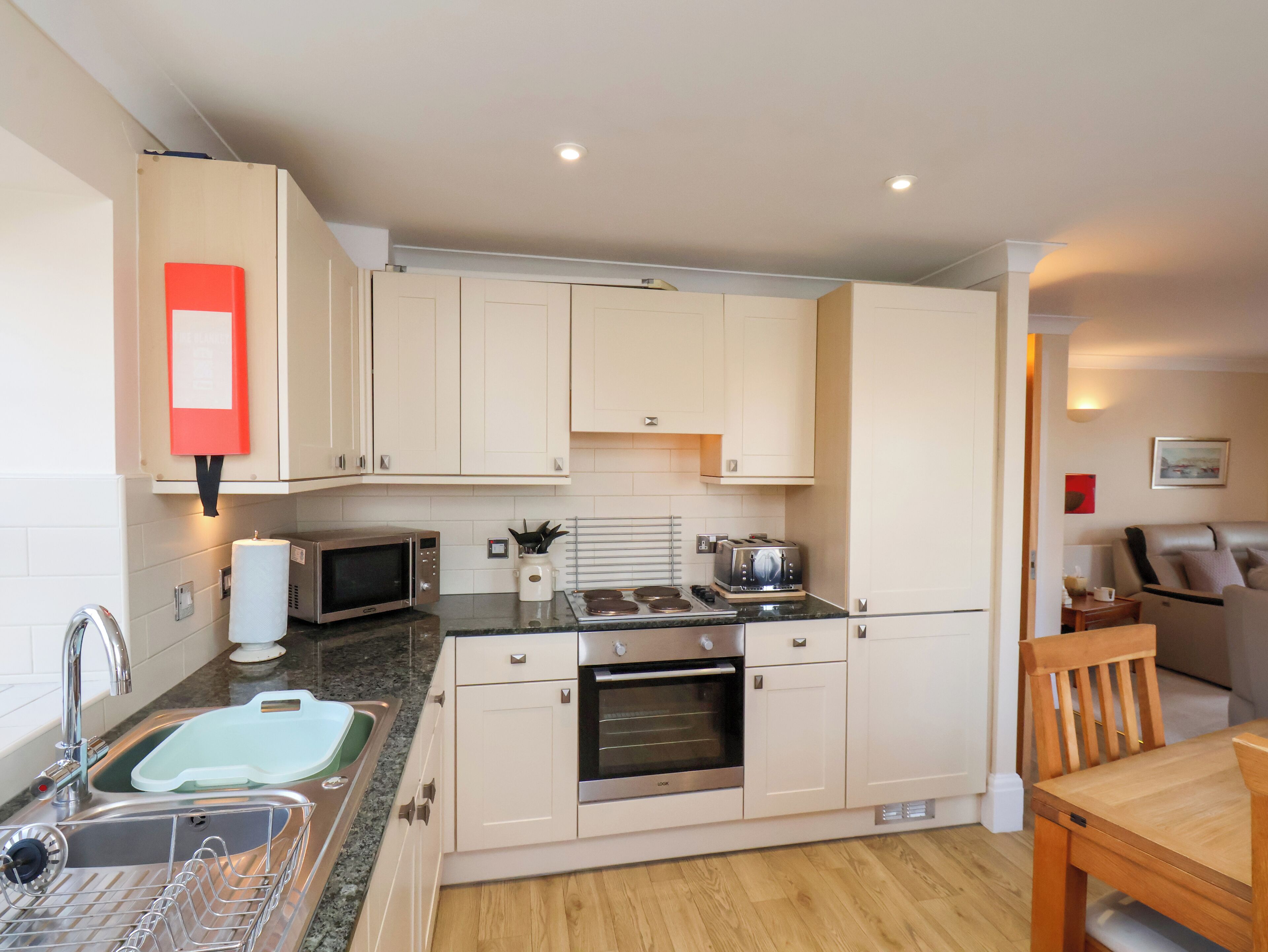 A compact kitchen with a sink, microwave, toaster, and oven.
