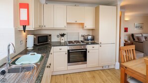A compact kitchen with a sink, microwave, toaster, and oven.