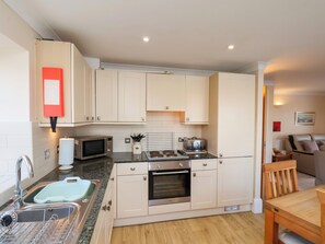 A compact kitchen with a sink, microwave, toaster, and oven.