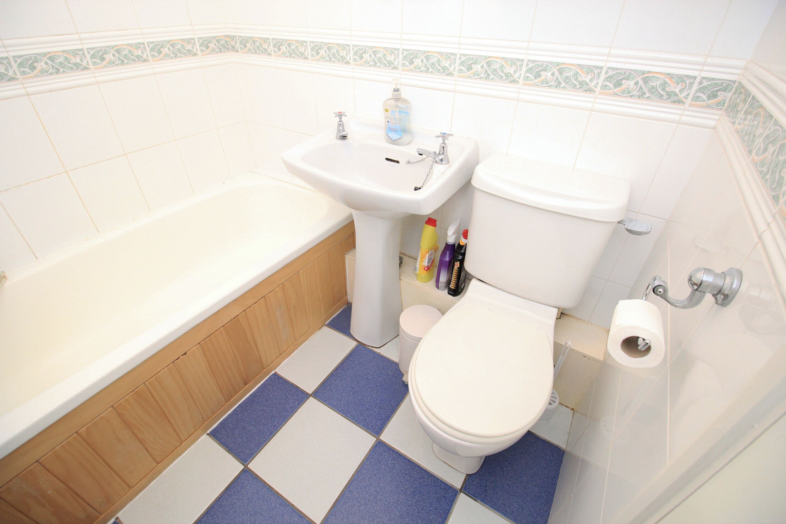Un baño con lavamanos, inodoro y bañera blancos.
