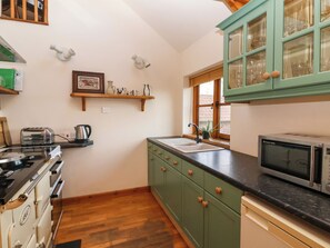 Een koelkast, een waterkoker, kookgerei, borden en bestek