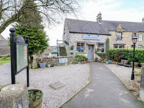A stone building with a sign for 'The Hartington Cheese Shop'.