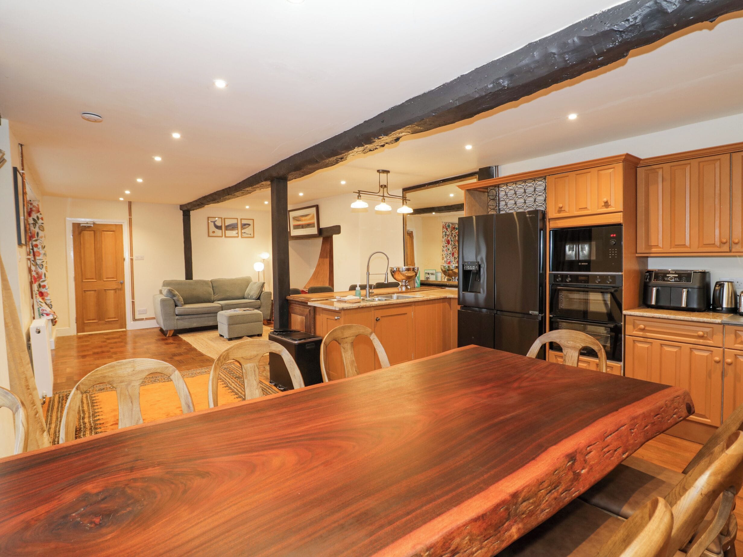 Une cuisine spacieuse, dotée de meubles en bois, d’un grand îlot central et d’appareils électroménagers modernes.