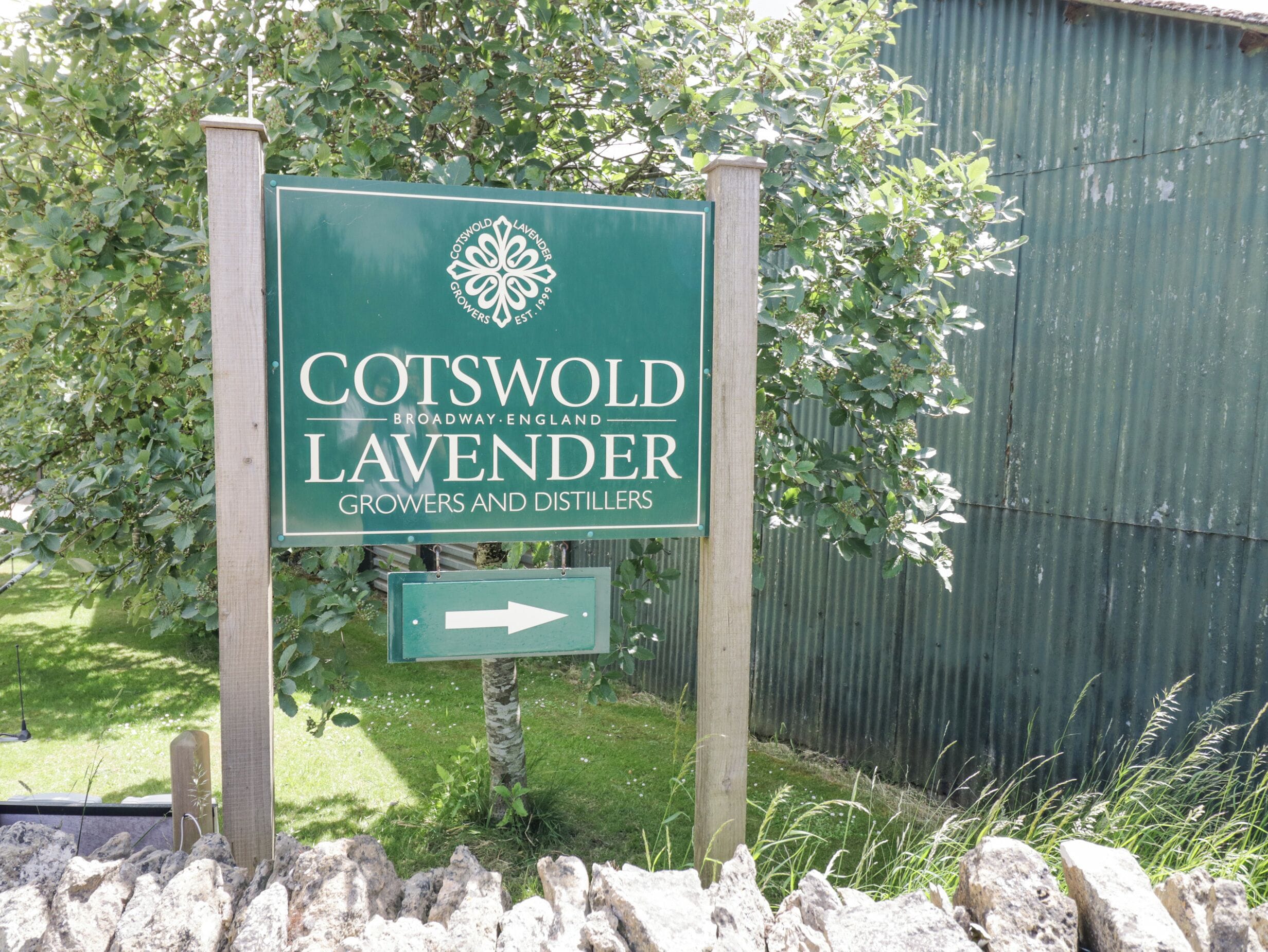 A sign for Cotswold Lavender Growers and Distillers with a directional arrow.
