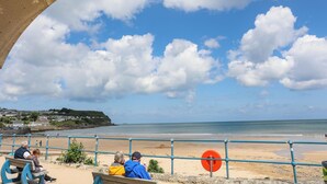 A beach with a clear sky, a sandy shore, and a view of the sea. - Sandy Bay Retreat (Tyn-y-Gongl)