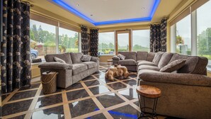 A spacious living room with two sofas, a coffee table, and a patterned rug. - Ullswater View House (Penrith)