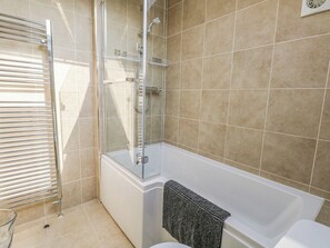 A modern bathroom with a glass-enclosed shower, a white bathtub, and a towel rack. - Home From Home (Portland)