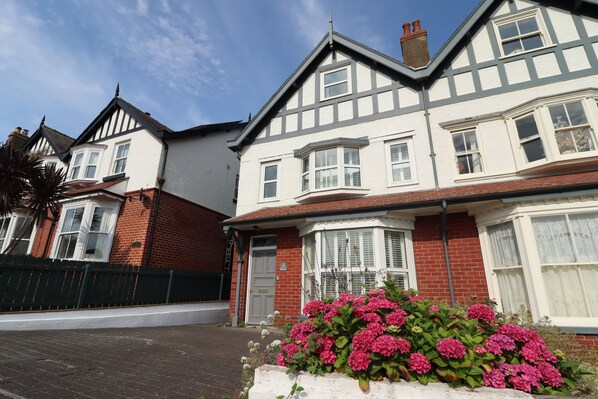 A two-story house with a bay window and a front door.