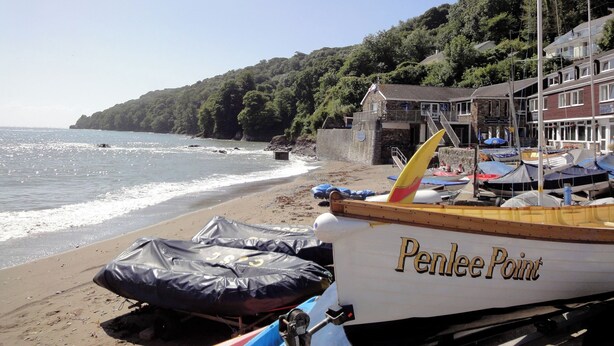 A beach with a boat named 'Penlee Point' and a building with a sign 'Penlee Point'. - Springfield (Torpoint)