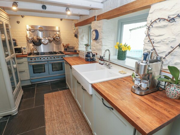 Een koelkast, een vaatwasser, kookgerei, borden en bestek