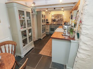 Een koelkast, een vaatwasser, kookgerei, borden en bestek