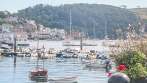 Un port où sont amarrés divers bateaux, avec un petit bateau au premier plan et des bâtiments en arrière-plan.