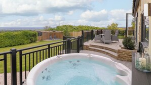 A hot tub on a patio with a view of the countryside. - Highview Stables (Chesterfield)