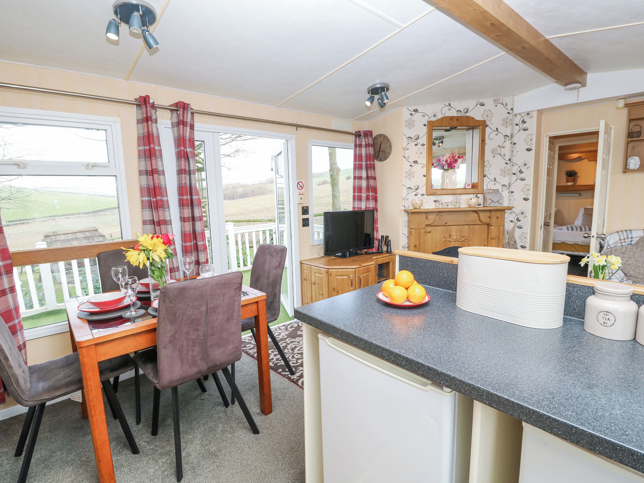 A cozy kitchen with a dining area, a television, and a view of the outdoors.