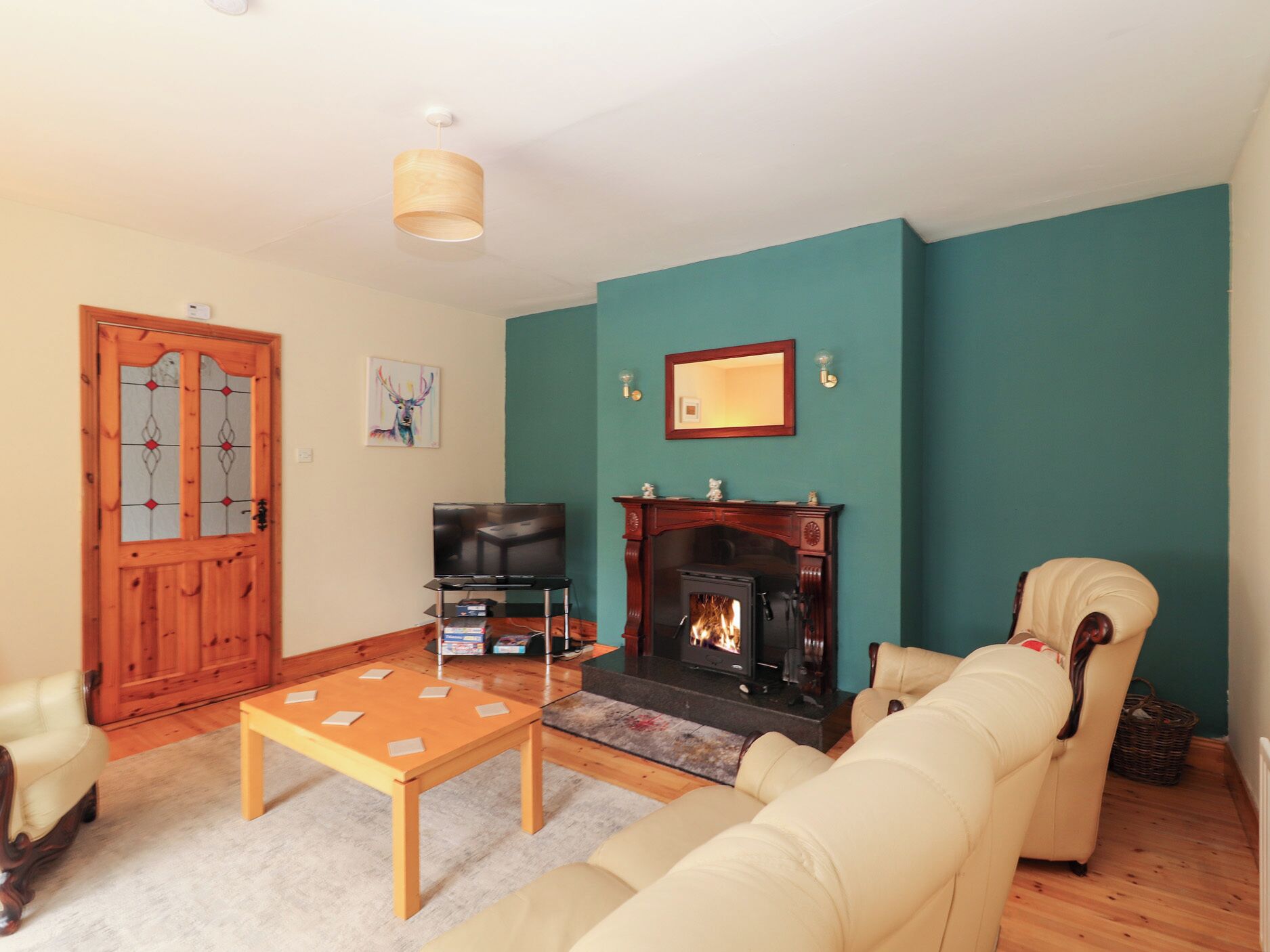 Una sala de estar con chimenea, televisor y sofá.