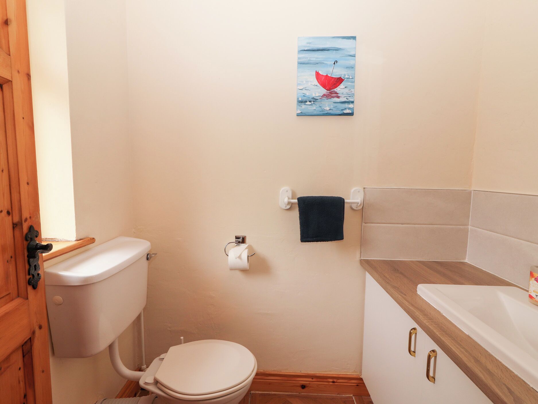 Ein kleines Badezimmer mit Toilette, Waschbecken und Handtuchhalter.